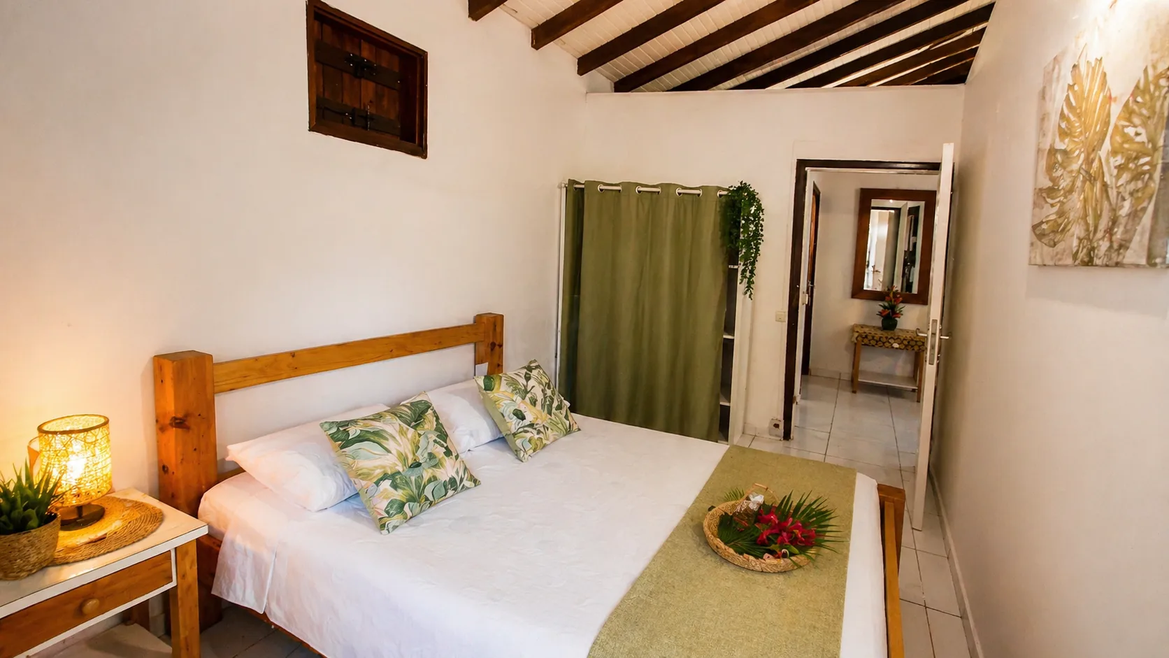 Chambre cosy avec lit double et touches tropicales